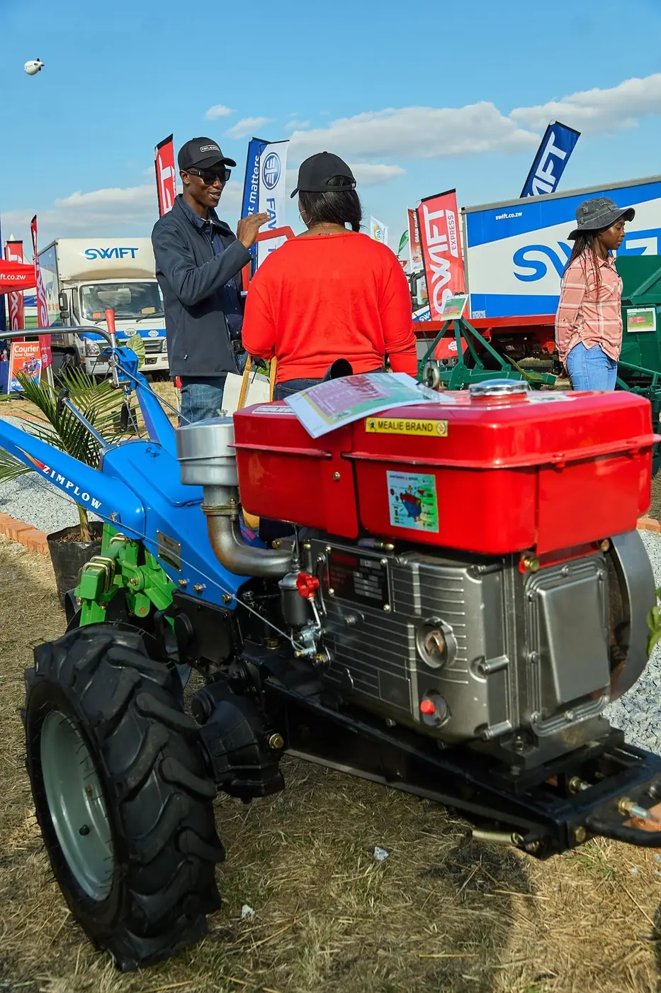 Mealie Brand 24HP two-wheel tractor on display, with a Mealie Brand team member talking to a visitor